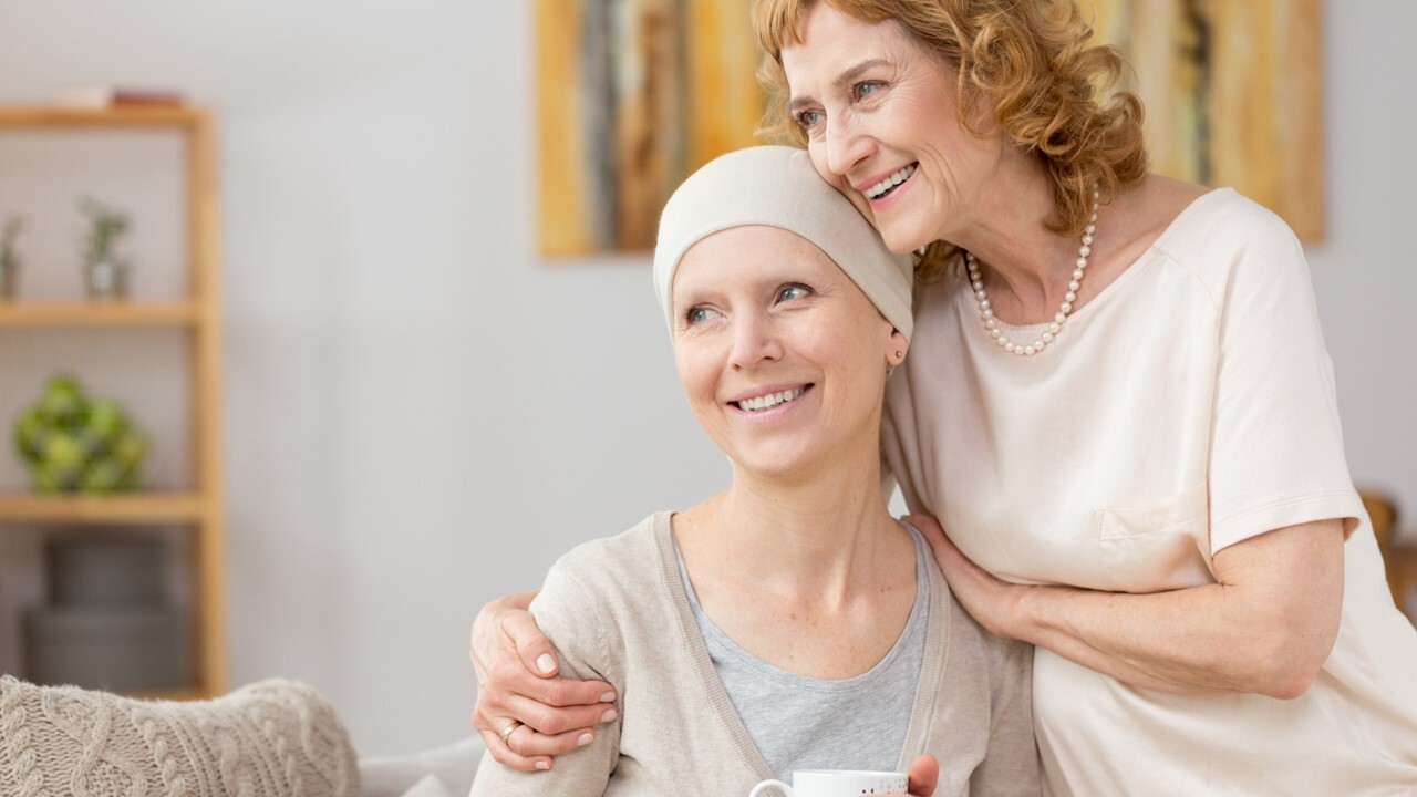 Cancer patient and woman in a warm embrace